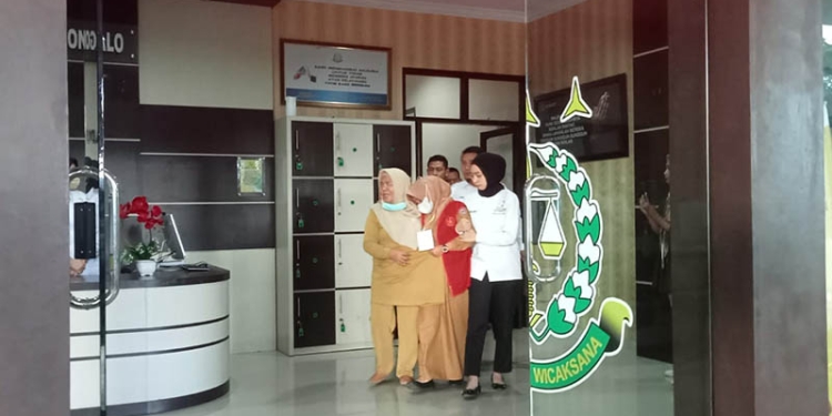 Salah satu tersangka kasus korupsi kredit Briguna di BRI Cabang Gorontalo Unit Aloei Saboe digiring petugas Kejaksaan menuju ke mobil tahanan untuk dibawa ke Lapas Gorontalo, Senin (3/10/2022).