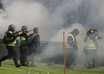 Aparat keamanan menembakkan gas air mata untuk menghalau suporter yang masuk lapangan usai pertandingan sepak bola BRI Liga 1 antara Arema melawan Persebaya di Stadion Kanjuruhan, Malang, Sabtu (1/10/2022). ANTARA/Suara.com