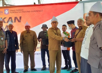 Penjabat Gubernur Gorontalo, Hamka Hendra Noer, bersama Plt Kepala Perwakilan BI Gorontalo, Miftahul Huda (kiri) membagikan bibit cabai di Pondok Pesantren Hubulo, Bone Bolango, Selasa (8/11/2022). (Indra/gopos)