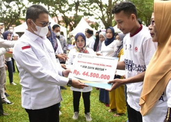 Penjagub Hamka Hendra Noer saat menyerahkan secara simbolis bantuan kepana pelaku IKM Provinsi Gorontalo, melalui kegiatan Temu Akbar Pelaku Usaha yang digelar di halaman kantor Dinas Koperasi, UMKM, Perindustrian dan Perdagangan (Diskumperindag), Jumat (18/11/2022). (Dinas Kominfo Provinsi Gorontalo)