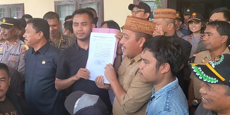 Ketua DPRD Bone Bolango, Halid Tangahu memperlihatkan persetujuan penandatanganan 
pelaksanaan FGD bersama pihak Aliansi Masyarakat Suwawa. (Foto: Putra/Gopos)