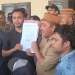 Ketua DPRD Bone Bolango, Halid Tangahu memperlihatkan persetujuan penandatanganan 
pelaksanaan FGD bersama pihak Aliansi Masyarakat Suwawa. (Foto: Putra/Gopos)