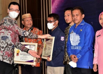 Deputi Reformasi Birokrasi Kemenpar-RB saat menyerahkan piagam penghargaan kepada Aparatur Sipil Negara (ASN) Provinsi Gorontalo pada kegiatan BerAKHLAK Award bertempat di Ballroom Hotel Aston,Jumat (14/10/2022). (Foto – Nova)