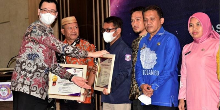 Deputi Reformasi Birokrasi Kemenpar-RB saat menyerahkan piagam penghargaan kepada Aparatur Sipil Negara (ASN) Provinsi Gorontalo pada kegiatan BerAKHLAK Award bertempat di Ballroom Hotel Aston,Jumat (14/10/2022). (Foto – Nova)