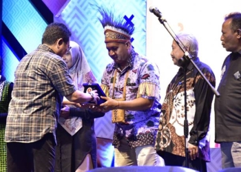 Penjabat Gubernur Gorontalo Hamka Hendra Noer saat menyerahkan plakat kepada peserta dari Provinsi Papua Barat sebagai juara favorit stand pameran penilaian dari Kementrian Pemuda dan Olahraga. (Foto : Alfred)
