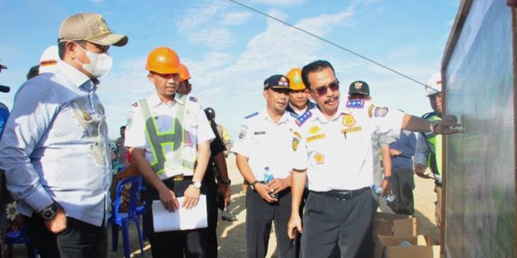 Kadis Perhubungan, Jamal Nganro (kanan), menjelaskan pekerjaan pembangunan Bandara Pohuwato kepada Penjagub Gorontalo, Hamka Hendra Noer (kiri), pada peninjauan pekerjaan di Desa Imbodu, Kecamatan Randangan, Kabupaten Pohuwato, Kamis (13/10/2022). (Foto : Haris)