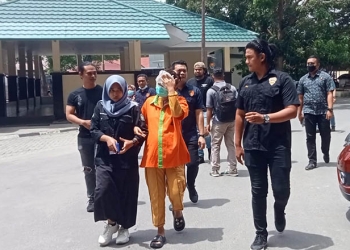 ZH digiring personel Polda Gorontalo untuk dihadirkan pada konferensi pers pengungkapan kasus pencurian perhiasan emas total 300 gram oleh Polda Gorontalo, Selasa (1/11/2022). (sari/gopos)