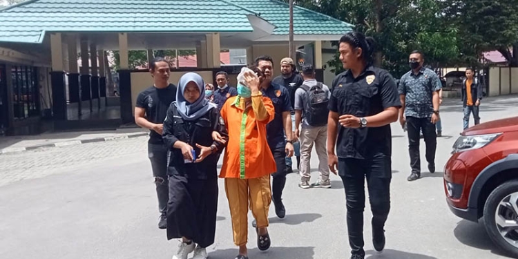 ZH digiring personel Polda Gorontalo untuk dihadirkan pada konferensi pers pengungkapan kasus pencurian perhiasan emas total 300 gram oleh Polda Gorontalo, Selasa (1/11/2022). (sari/gopos)