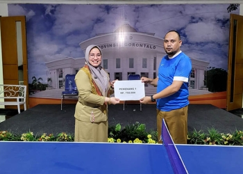 Kabag Humas Deprov Gorontalo, Yani Uno (kanan) menerima hadiah juara I turnamen tenis meja menyemarakkan HUT Provinsi Gorontalo.
