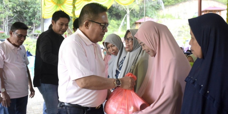 Wali Kota Gorontalo, Marten Taha membagikan sembako kepada masyarakat saat kegiatan Family Gathering bersama PDAM Muara Tirta, Sabtu (24/12/2022). (Foto: Humas)