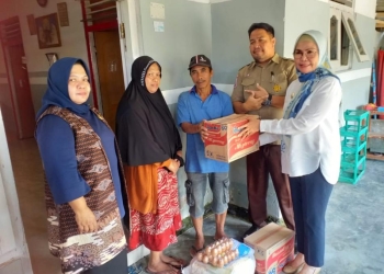 Wakil Bupati Bone Bolango, Merlan S. Uloli didampingi Kepala Pelaksana BPBD, Achril Babiyonggo dan Camat Suwawa Tengah, Oktavianus Tangahu saat menyerahkan bantuan kepada korban longsor di Desa Tolomato, Kecamatan Suwawa Tengah, Rabu (13/9/2022). (Foto Indra/Gopos)