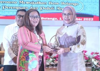 Peduli Perlindungan Perempuan dan Anak, Wabup Merlan saat menerima Penghargaan Gender Champion yang diserahkan oleh Asisten Deputi Perlindungan Khusus Anak dan Kekerasan Kementerian Pemberdayaan Perempuan dan Perlindungan Anak RI, Ciput Eka Purwianti pada kegiatan workshop Desa Ramah Perempuan dan Peduli Anak (DRPPA) tingkat Kabupaten Bone Bolango tahun 2022, di Aula BPMP Provinsi Gorontalo, di Kecamatan Tilongkabila, Kamis (1/12/2022).