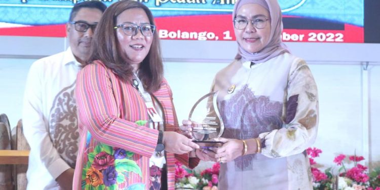 Peduli Perlindungan Perempuan dan Anak, Wabup Merlan saat menerima Penghargaan Gender Champion yang diserahkan oleh Asisten Deputi Perlindungan Khusus Anak dan Kekerasan Kementerian Pemberdayaan Perempuan dan Perlindungan Anak RI, Ciput Eka Purwianti pada kegiatan workshop Desa Ramah Perempuan dan Peduli Anak (DRPPA) tingkat Kabupaten Bone Bolango tahun 2022, di Aula BPMP Provinsi Gorontalo, di Kecamatan Tilongkabila, Kamis (1/12/2022).