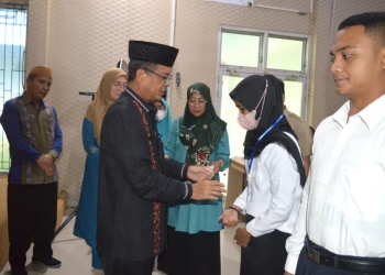 Sekda Ishak Ntoma menyematkan kartu tanda peserta Pelatihan Berbasis Komputer (PBK) angkatan III, di Aula Tolopani Kantor Bappeda-Litbang Bone Bolango, Kamis (8/9/2022). (Foto AKP/Diskominfo)
