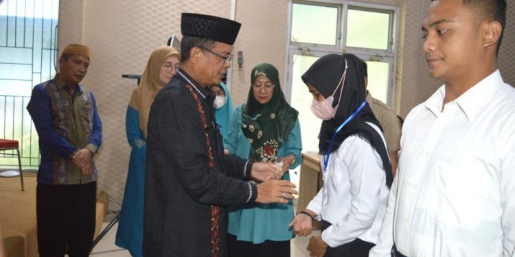 Sekda Ishak Ntoma menyematkan kartu tanda peserta Pelatihan Berbasis Komputer (PBK) angkatan III, di Aula Tolopani Kantor Bappeda-Litbang Bone Bolango, Kamis (8/9/2022). (Foto AKP/Diskominfo)