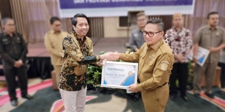 Universal Health Care (UHC) atau Cakupan Kesehatan Semesta di Kota Gorontalo tembus di angka 98,36 Persen. Wali Kota Gorontalo, Marten Taha saat menerima piagam penghargaan dari BPJS Kesehatan di Hotel Aston Kota Gorontalo, Selasa (20/12/2022). (Foto: Putra/Gopos)