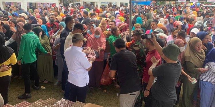 Penjabat Gubernur Gorontalo, Hamka Hendra Noer ikut membagikan komoditas untuk warga di pasar murah yang dilaksanakan Pemprov Gorontalo di Kelurahan Padebuolo, Kecamatan Kota Timur, Kota Gorontalo, Ahad (4/12/2022) (muhajir/gopos)