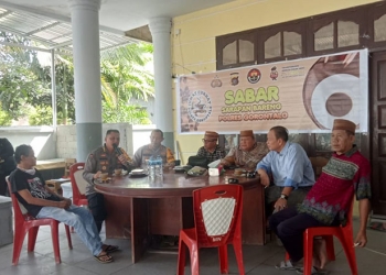 Kabid Humas Polda Gorontalo, Kombes Pol Wahyu Tri Cahyono, bersama Kapolres Gorontalo, AKBP Dadang Wijaya, dan masyakarat setempat saat menggelar sarapan bareng (sabar) di warung kopi Pinogu, Jumat (30/12/2022). Sari/gopos