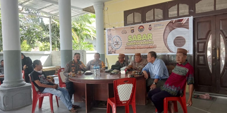 Kabid Humas Polda Gorontalo, Kombes Pol Wahyu Tri Cahyono, bersama Kapolres Gorontalo, AKBP Dadang Wijaya, dan masyakarat setempat saat menggelar sarapan bareng (sabar) di warung kopi Pinogu, Jumat (30/12/2022). Sari/gopos