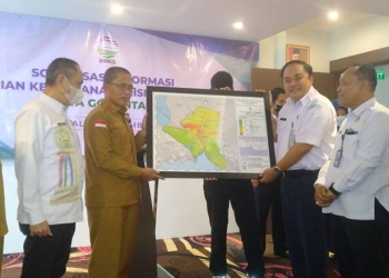 Kepala Stasiun Geofisika Manado, Tony Agus Wijaya memberikan peta hasil kajian mengenai wilayah kerentanan gempa di Kota Gorontalo yang diterima oleh Sekda Kota Gorontalo, Ismail Majid, Senin (5/12/2022) (muhajir/gopos)