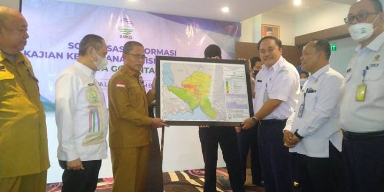Kepala Stasiun Geofisika Manado, Tony Agus Wijaya memberikan peta hasil kajian mengenai wilayah kerentanan gempa di Kota Gorontalo yang diterima oleh Sekda Kota Gorontalo, Ismail Majid, Senin (5/12/2022) (muhajir/gopos)