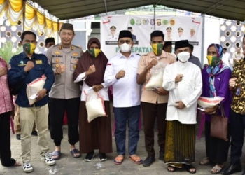 Penjagub Hamka didampingi Bupati Kabupaten Gorontalo Nelson Pomalingo saat menyerahkan beras kepada masyarakat usai melakukan vaksin, pada penyelenggaraan vaksinasi massal yamh digagas oleh Pemda Kabgor, di Halaman Masjid Baitulrahman Limboto, Jumat (2/12/2022). (Foto – Fikry)