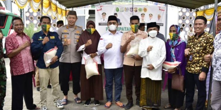 Penjagub Hamka didampingi Bupati Kabupaten Gorontalo Nelson Pomalingo saat menyerahkan beras kepada masyarakat usai melakukan vaksin, pada penyelenggaraan vaksinasi massal yamh digagas oleh Pemda Kabgor, di Halaman Masjid Baitulrahman Limboto, Jumat (2/12/2022). (Foto – Fikry)