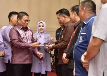 Penjagub Hamka Hendra Noer saat menyerahkan piagam penghargaan kepada pegawai dan organisasi perangkat daerah (OPD) yang terbaik dalam hal Laporan Harta Kekayaan Pejabat Negara (LHKPN). Penghargaan diberikan pada puncak peringatan Hari Antikorupsi Sedunia tahun 2022 yang dilaksanakan oleh Inspektorat Provinsi Gorontalo dan berlangsung di Grand Palace Convention Center, Kota Gorontalo, Kamis (8/12/2022). (Foto – Fikri)