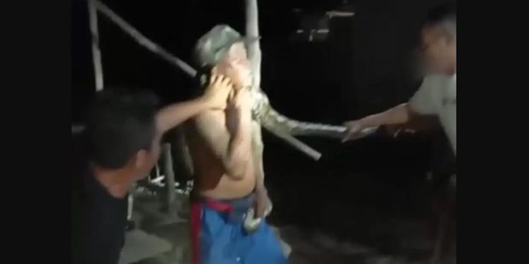 Dua warga berusaha melepaskan lilitan ular piton pada leher Iko Kamsuah, warga Desa Waluhu, Kecamatan Bone, Kabupaten Bone Bolango, Gorontalo. (istimewa)