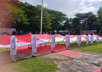 Pasukan Pengibar Bendera Pusaka (Paskibraka) Provinsi Gorontalo dan Kabupaten Bone Bolango saat membentangkan Bendera Merah Putih sepanjang 23 meter di Halaman Kantor Bupati Bone Bolango pada Peringatan Hari Patriotik 23 Januari, Senin (23/1/2023). (Foto Indra/Gopos)