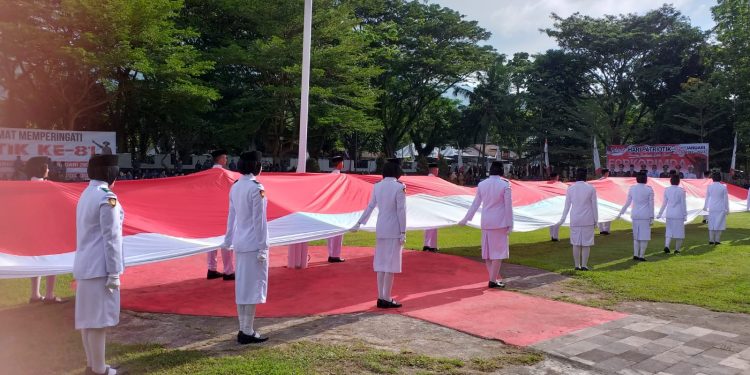 Pasukan Pengibar Bendera Pusaka (Paskibraka) Provinsi Gorontalo dan Kabupaten Bone Bolango saat membentangkan Bendera Merah Putih sepanjang 23 meter di Halaman Kantor Bupati Bone Bolango pada Peringatan Hari Patriotik 23 Januari, Senin (23/1/2023). (Foto Indra/Gopos)