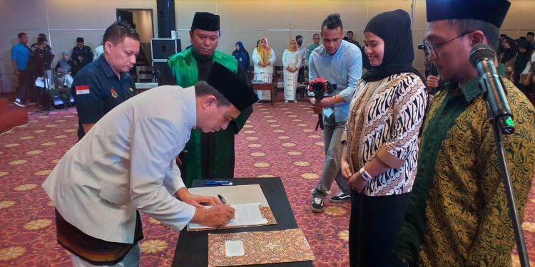 Ketua KPU Bone Bolango, Adnan Berahim saat menandatangani berita acara pengambilan sumpah dan pelantikan 495 PPS di Citymall Hotel Gorontalo, Selasa (24/1/2023). (Foto Indra/Gopos)