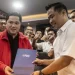Menteri BUMN Erick Thohir (kiri) menerima berkas dari panitia usai melakukan pendaftaran calon Ketua Umum PSSI periode 2023-2027 di Kantor PSSI, GBK Arena, Senayan, Jakarta, Minggu (15/1/2023). ANTARA FOTO/Aprillio Akbar/nz