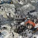 Gambar udara menunjukkan penduduk, dibantu oleh alat berat, mencari korban dan penyintas di tengah puing-puing bangunan yang runtuh setelah gempa bumi di desa Besnia dekat Harim, di provinsi Idlib, Suriah, Senin (6/2/2023). [Omar HAJ KADOUR/AFP]