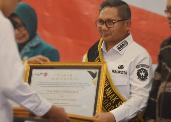 Wali Kota Gorontalo, Marten Taha saat menerima piagam pengukuhan sebagai bapak asuh stunting di Hotel Aston, Kota Gorontalo, Rabu (15/2/2023). (Foto: Putra/Gopos)