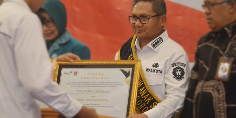 Wali Kota Gorontalo, Marten Taha saat menerima piagam pengukuhan sebagai bapak asuh stunting di Hotel Aston, Kota Gorontalo, Rabu (15/2/2023). (Foto: Putra/Gopos)