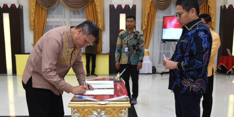 Penjagub Gorontalo, Hamka Hendra Noer, menyaksikan penandatanganan PK dan PI oleh pimpinan organisasi perangkat daerah di aula rumah jabatan Gubernur Gorontalo, Jumat (17/2/2023). (Kominfo Provinsi Gorontalo)