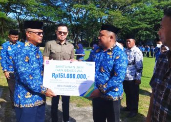 Sekda Bone Bolango, Ishak Ntoma yang turut didampingi Kepala BPJS Ketenagakerjaan Cabang Gorontalo, Arif Budiman saat menyerahkan santunan kepada ahli waris anggota Korpri, Jumat (17/2/2023). (Foto AKP/Diskominfo)