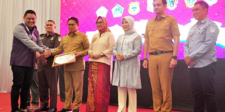 Direktur PT. Rumah UMKM Indonesia, Taufik Akbar, menyerahkan penghargaan kepada Penjagub Gorontalo, Hamka Hendra Noer, pada peluncuran toko daring BeliUMKM mitra LKPP di Grand Palace Convention Center, Kota Gorontalo, Selasa (7/2/2023). (Foto : Haris)