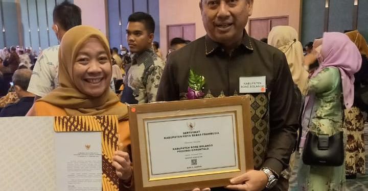 Bupati Bone Bolango, Hamim Pou didampingi Kepala Dinas Kesehatan, dr. Meyrin Kadir saat menerima Sertifikat Bebas Frambusia dari Kementerian Kesehatan Republik Indonesia di Peringatan Hari Neglected Tropical Diseases/NTDs (penyakit tropis terabaikan) Sedunia di Krakatau Grand Ballroom Taman Mini Indonesia Indah Jakarta, Selasa (21/2/2023). (Foto Istimewa)