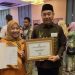 Bupati Bone Bolango, Hamim Pou didampingi Kepala Dinas Kesehatan, dr. Meyrin Kadir saat menerima Sertifikat Bebas Frambusia dari Kementerian Kesehatan Republik Indonesia di Peringatan Hari Neglected Tropical Diseases/NTDs (penyakit tropis terabaikan) Sedunia di Krakatau Grand Ballroom Taman Mini Indonesia Indah Jakarta, Selasa (21/2/2023). (Foto Istimewa)