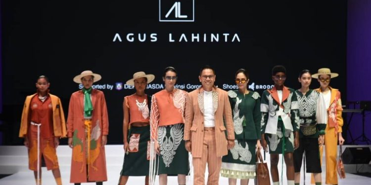 Agus Lahinta foto bersama model yang memamerkan karya karyanya di pembukaan Indonesia Fashion Week 2023, Rabu (22/2/2023). Agus mengusung tema oduolo yang berarti terima kasih dengan menampilkan identitas khas Gorontalo. (FOTO: Isam – Diskominfotik).