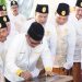 Wali Kota Gorontalo, Marten Taha saat menandatangani Prasasti Duango Adati Lo Hulonthalo di Rumah Adat Dulohupa, Kota Gorontalo, Ahad (5/3/2023). (Foto: Humas)