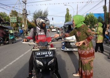 Ketua Pimpinan Cabang Muslimat NU Bone Bolango, Merlan S. Uloli bersama para anggota saat membagikan paket takjil buka puasa di Peringatan Harlah Muslimat NU ke-77, Rabu (29/3/2023). (Foto Indra/Gopos)