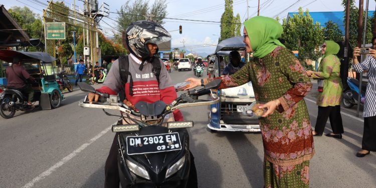 Ketua Pimpinan Cabang Muslimat NU Bone Bolango, Merlan S. Uloli bersama para anggota saat membagikan paket takjil buka puasa di Peringatan Harlah Muslimat NU ke-77, Rabu (29/3/2023). (Foto Indra/Gopos)