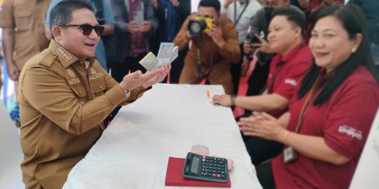 Wali Kota Gorontalo, Marten Taha saat menghadiri kegiatan Layanan penukaran uang pecahan kecil bagi masyarakat di Lapangan Taruna Remaja, Kota Gorontalo, Senin (10/3/2023). (Foto: Putra/Gopos)