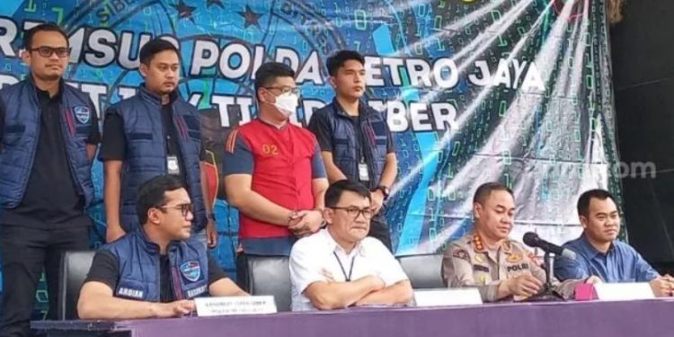M Iman Mahlil Lubis (pakai rompi tahanan) tersangka penipuan modus QRIS palsu kotak amal masjid saat dirpamerkan dalam kasus yang dirilis Polda Metro Jaya. (F. Suara.com/M Yasir)