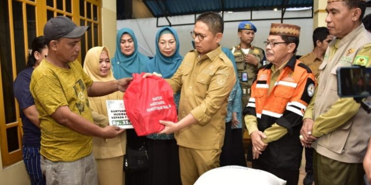 Penjabat Gubernur Gorontalo Hamka Hendra Noer didampingi istri yang juga Ketua TP-PKK Provinsi Gorontalo drg. Gamaria Purnamawati Monoarfa, saat menyerahkan bantuan korban kebakaran di Kelurahan Tamalate, Kecamatan Kota Timur, Kota Gorontalo, Senin (10/4/2023). Foto – Fikry