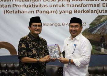 Hamim Pou dan Fadel Muhammad saling bertukar buku pada Pada kegiatan Workshop Evaluasi Pengelolaan Keuangan dan Pembangunan Desa yang digelar di Kabupaten Bone Bolango kemarin. (Foto Cila/Prokopim)