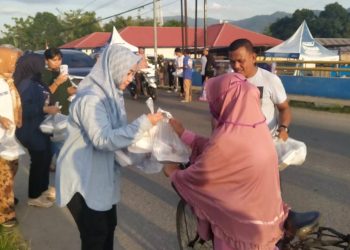 Pemilik PT. Azwa Utama Rakhmatiyah Deu saat membagikan paket makanan di Ulahuta, Kecamatan Kabila, Kabupaten Bone Bolango, Ahad (9/4/2023) (muhajir/gopos)